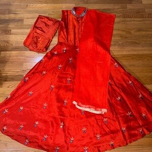 Indian traditional bright orange gown with dupatta.